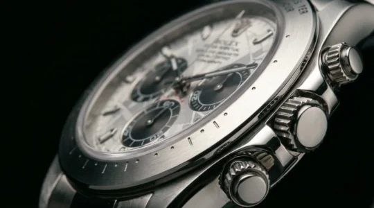 Dettaglio ravvicinato di un cronografo meccanico con scala tachimetrica visibile e pulsanti laterali