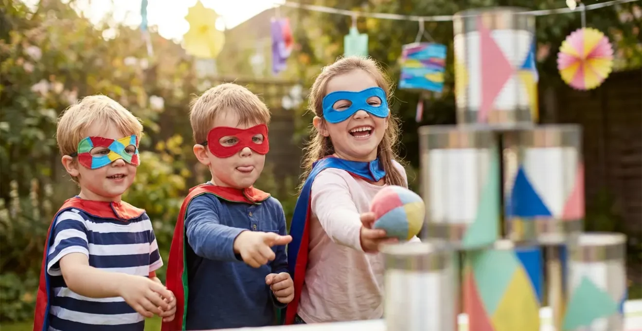 Bambini in azione durante giochi a tema supereroi in giardino